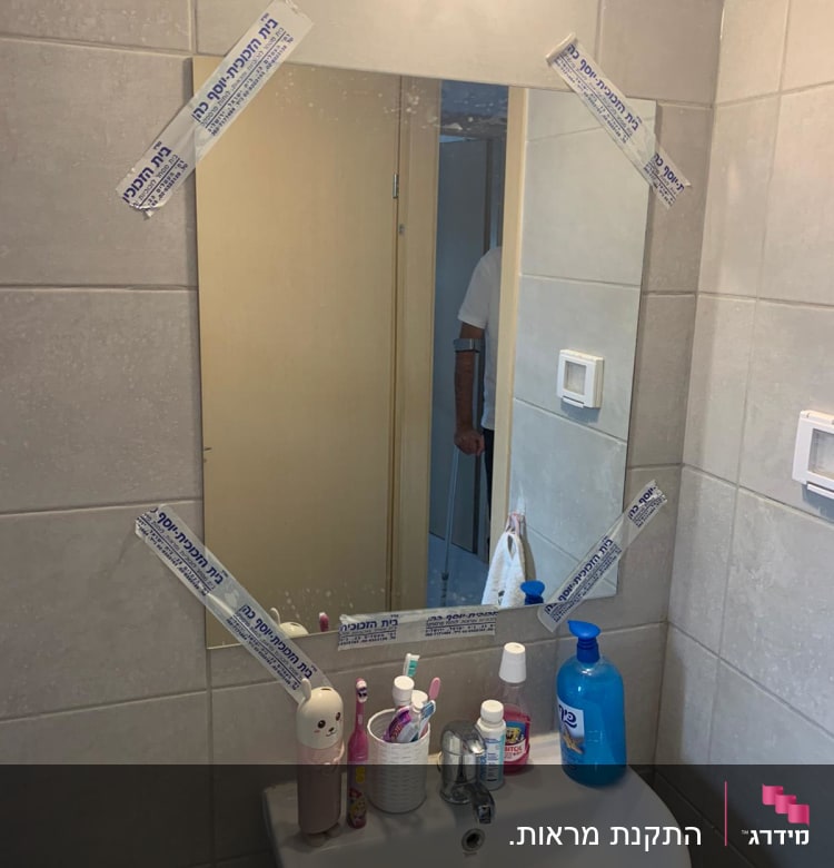 מראה עם מדבקות על הקצוות בחדר אמבטיה